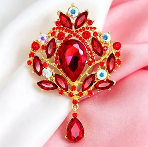 Détail d'une broche couronne vintage dorée ornée de cristaux rouge rubis étincelants