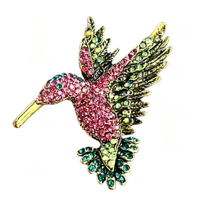 Vista dettagliata che mostra gli intricati strass colorati su una spilla a colibrì.