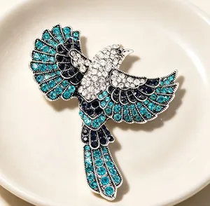 Detailaufnahme einer Vintage-Elster-Brosche mit funkelnden blauen Strasssteinen