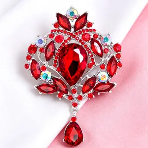 Vue détaillée d'une broche couronne vintage avec cristaux rouges et pendentif goutte