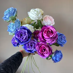Vista detallada de rosas de seda de 3 cabezas de colores en un ramo decorativo elegante.