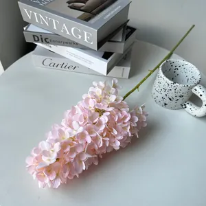 Close-up of a pink artificial hydrangea branch in a stylish home decor setting.