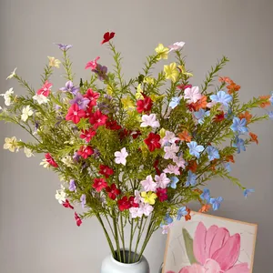 Vibrant multi-color artificial periwinkle wildflowers detail in a blue ceramic vase