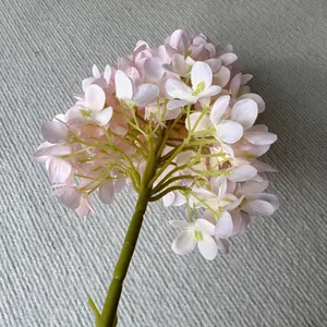 Detailed view of a light pink artificial hydrangea flower with realistic green stem.