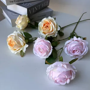 Detalle macro de rosas de seda realistas en rosa y champán con tallos verdes naturales