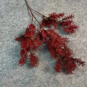 Macro detail of dark red artificial asparagus fern greenery for wedding floral decor