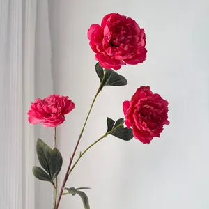 Vista detallada de tres peonías artificiales con bordes quemados en un tono rosa magenta.