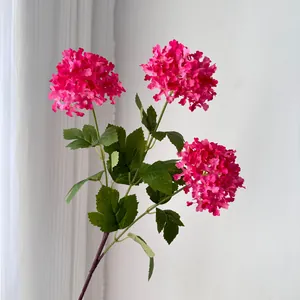 Detailed view of three-head magenta artificial hydrangea with realistic green leaves
