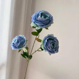 Vista detallada de rosas de seda artificiales de tres cabezas en color azul polvoriento.