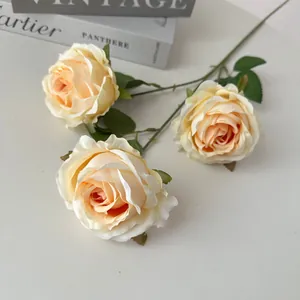 Vista detallada de tres rosas de seda color crema con hojas verdes realistas para decorar.