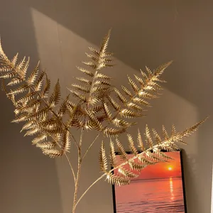 Vue détaillée d'une branche de fougère artificielle dorée pour les fleurs du Nouvel An