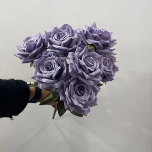 Detailed view of a 9-head European style artificial purple rose bouquet held by hand