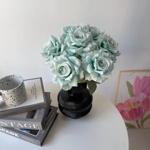 Elegant close-up of artificial mint green 7-head silk roses in a black ribbed vase