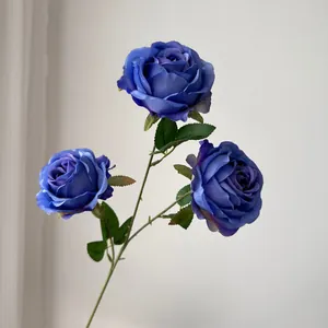 Primer plano detallado de rosas de seda artificiales de color púrpura oscuro de tres cabezas