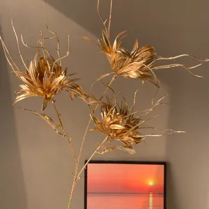 Gros plan d'une tige florale artificielle dorée élégante pour décor de Nouvel An