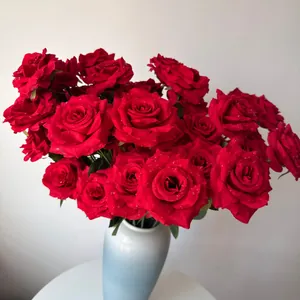 Detailed view of realistic red artificial roses featuring delicate water droplets