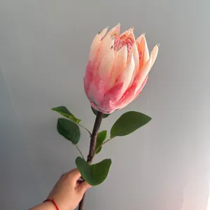 Vista detallada de una flor artificial de protea real rosa con textura suave flocada