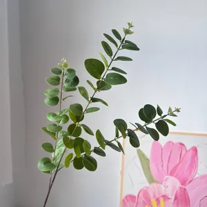 Close-up of lifelike artificial eucalyptus stems with green round leaves for decor