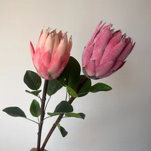 Detalle de dos flores de protea artificiales flocadas con textura aterciopelada
