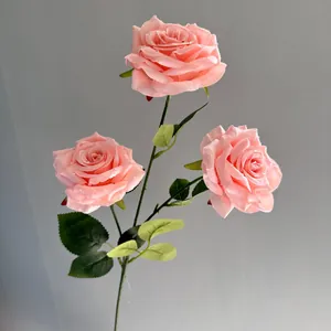 Detail view of pink three-head artificial roses with realistic water droplets
