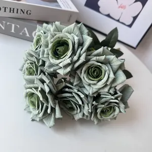 Close-up detail of artificial dusty green rose bouquet with realistic petal textures.