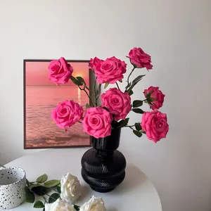 Detailed view of pink silk roses with realistic water droplets in a black textured vase