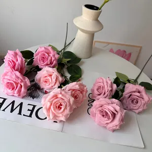 Close-up detail of pink artificial roses featuring lifelike water droplets on petals.