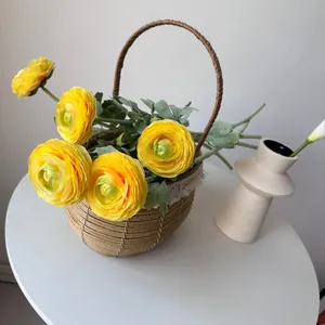 Vibrant yellow flocked ranunculus flowers presented in a rustic woven basket decor