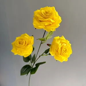 Detailed view of artificial yellow roses with realistic water droplets on petals