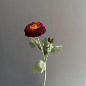 Close-up detail of a realistic flocked two-head Ranunculus artificial flower in burgundy red