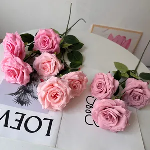 Detailed view of artificial pink roses featuring realistic water droplets on soft petals