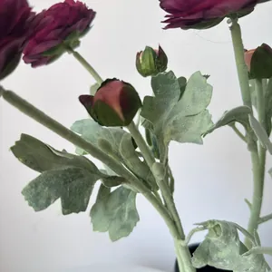 Close-up detail of burgundy flocked artificial ranunculus flowers and fuzzy leaves