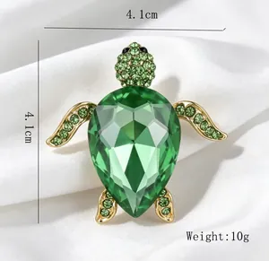 Vue détaillée d'une broche tortue en cristal vert de 4,1 cm avec des strass brillants.