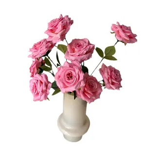 Realistic pink artificial rose bouquet with water droplets in a minimalist vase