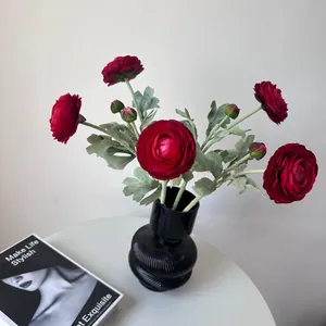 Detailed macro view of red flocked ranunculus artificial flowers in a black textured vase.