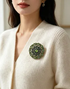 Vintage luxury green rhinestone wreath brooch on a white cardigan for an elegant look