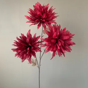 Detailopname van drie donkerrode kunstmatige vlamchrysantenbloemhoofden op een steel.