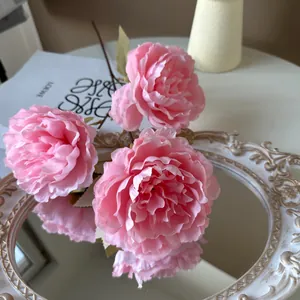 Detaillierte Makroansicht rosa künstlicher Seidenpfingstrosen auf einem Vintage-Spiegeltablett