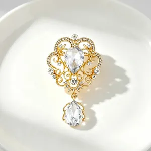 Vintage gold palace style crown brooch decorated with sparkling teardrop crystal pendant