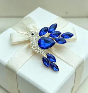 Exquisite blue crystal hummingbird brooch with rhinestones shown on a white gift box