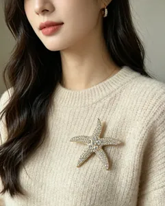 Detalle de un lujoso broche de estrella de mar vintage con pedrería en jersey beige