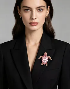 Vue détaillée d'une broche tortue en cristal rose de luxe portée sur un revers de blazer noir.