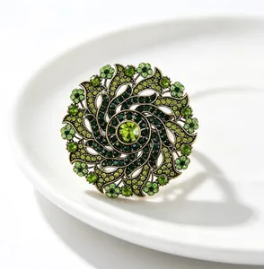 Detailed macro shot of vintage gold flower brooch with sparkling green rhinestones