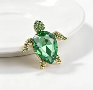 Gros plan détaillé d'une broche tortue en cristal vert étincelant avec finition dorée