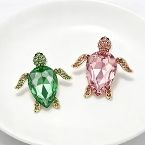 Broches tortue de mode élégantes avec strass en vert et rose sur une assiette en céramique