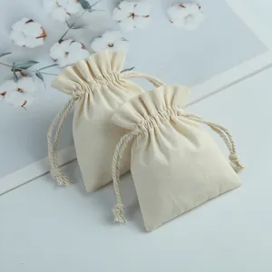 Detail of cream-colored cotton drawstring pouches with natural rope closures