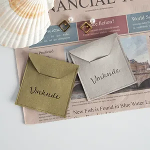 Detail view of microfiber jewelry pouches in olive and grey with embossed logo