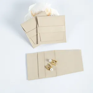 Vista detallada de la bolsa de joyería de microfibra de gamuza beige con solapa y aretes