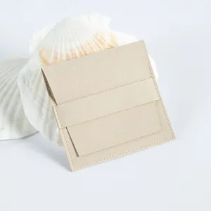 Primer plano detallado de una bolsa de microfibra beige para joyas con solapa