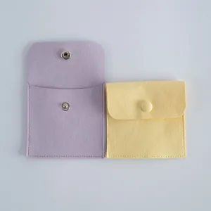 Vue détaillée des pochettes à bijoux en velours lavande et jaune avec bouton pression